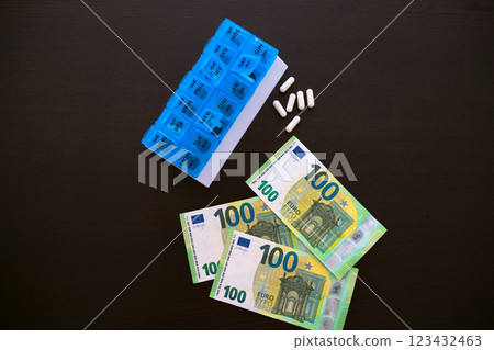 White tablets next to the tablet on a black table. one hundred euros. White tablets next to the tablet on a black table. one hundred euros. 123432463