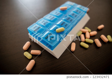 Blue tablet on a black table with scattered green and pink pills Blue tablet on a black table with scattered green and pink pills 123432471