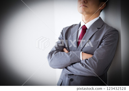 A middle-aged male businessman wearing a gray suit and worried 123432528