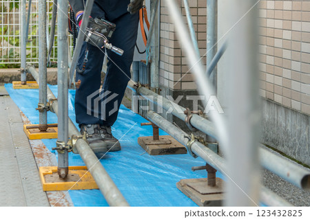 [Workers building scaffolding during large-scale apartment repair work] 123432825