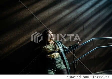 Portrait of a young Asian woman posing in the subway near the stairs. Portrait of a young Asian woman posing in the subway near the stairs. 123433044
