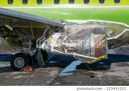 An airplane turbine undergoing repairs is wrapped in film. An airplane turbine undergoing repairs is wrapped in film. 123433131