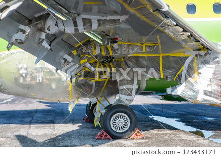 Airplane undergoing repairs in the open air. Airplane undergoing repairs in the open air. 123433171