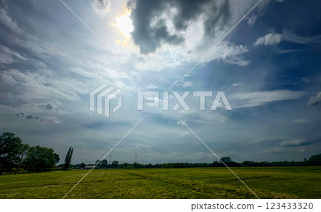 Expansive Green Fields Stretching Out Beneath a Dramatic and Beautiful Sky High Above 123433320