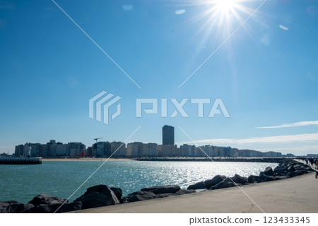 Oostend, Belgium, October 6th, 2024, A coastal cityscape under bright sunlight, with waves gently 123433345