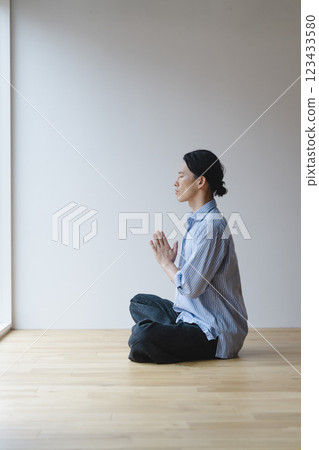 一名 40 多歲的男子坐在地板上冥想 123433580