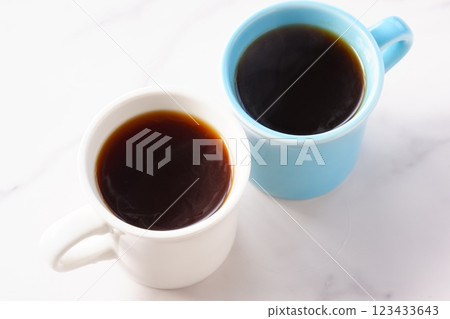 An image of two people having a meeting while drinking coffee from two mugs filled with freshly brewed coffee 123433643