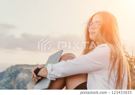 Woman, Laptop, Sunset: Young woman with laptop enjoying a beautiful sunset view on a mountaintop. Woman, Laptop, Sunset: Young woman with laptop enjoying a beautiful sunset view on a mountaintop. 123433835