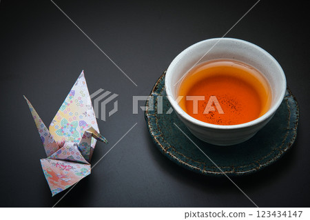 A crane made from Japanese origami paper and roasted green tea served on a tea tray A crane made from Japanese origami paper and roasted green tea served on a tea tray 123434147