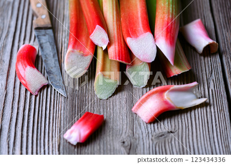 Ripe pink rhubarb stalks with knife on a wooden table Ripe pink rhubarb stalks with knife on a wooden table 123434336