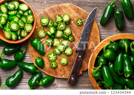 Sliced green jalapeno on wooden cutting board 123434344