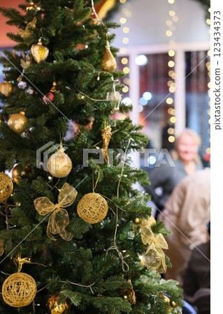 A festive Christmas tree decorated with sparkling golden ornaments, creating a cheerful vibe A festive Christmas tree decorated with sparkling golden ornaments, creating a cheerful vibe 123434373