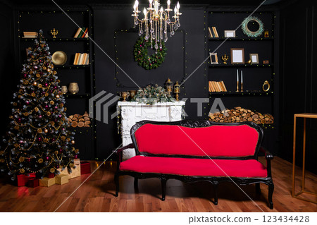 black sofa with red upholstery against black wall christmas tree. classic area with sofa fireplace black sofa with red upholstery against black wall christmas tree. classic area with sofa fireplace 123434428