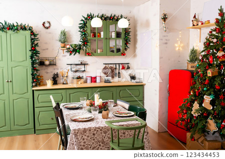 Christmas table with white tablecloth New Year tree green furniture. New Year's kitchen photo zone Christmas table with white tablecloth New Year tree green furniture. New Year's kitchen photo zone 123434453