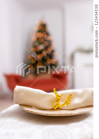 New Year's table setting in a photo studio. Plates with glasses on a Christmas tablecloth 123434538