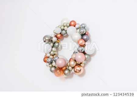New Year wreath made of plastic colored balls. Christmas decoration on a light wall 123434539