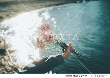 Sparkling water surface and pink bouquet in hand Cinematic film style 123434886