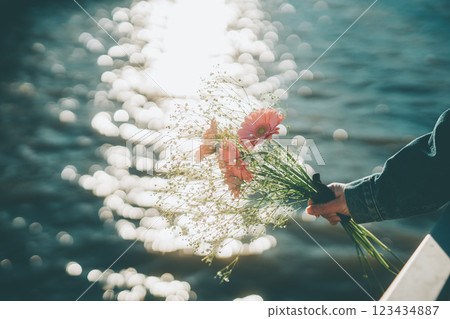 Sparkling water surface and pink bouquet in hand Cinematic film style 123434887
