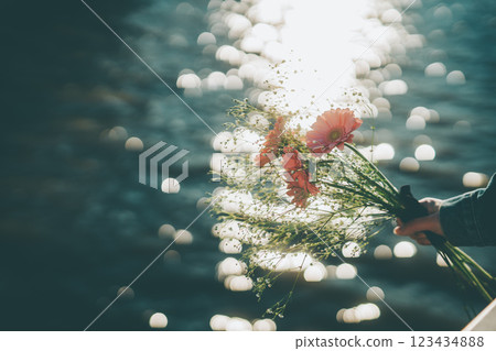 Sparkling water surface and pink bouquet in hand Cinematic film style Sparkling water surface and pink bouquet in hand Cinematic film style 123434888