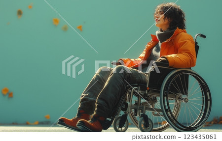 Young girl sitting in a wheelchair on a green background. 123435061