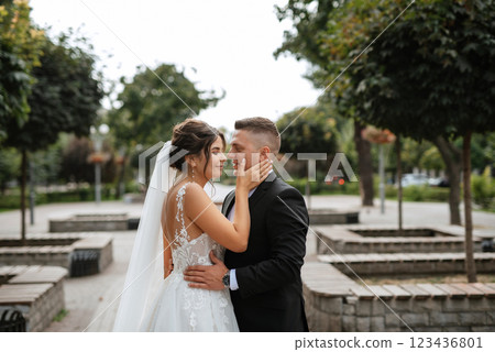the groom in a brown suit and the bride in a white dress 123436801