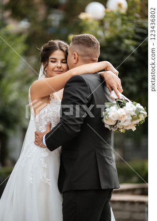 the groom in a brown suit and the bride in a white dress the groom in a brown suit and the bride in a white dress 123436802