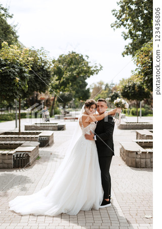 the groom in a brown suit and the bride in a white dress the groom in a brown suit and the bride in a white dress 123436806