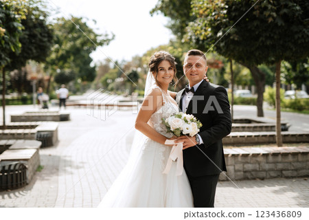 the groom in a brown suit and the bride in a white dress 123436809