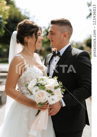 the groom in a brown suit and the bride in a white dress the groom in a brown suit and the bride in a white dress 123436813