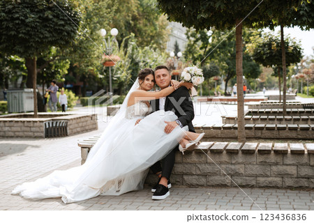 the groom in a brown suit and the bride in a white dress 123436836