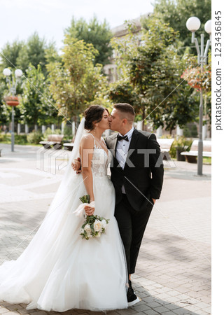 the groom in a brown suit and the bride in a white dress 123436845