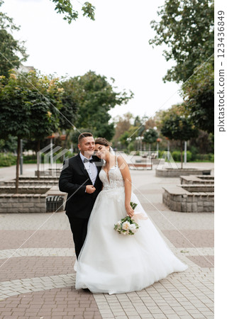 the groom in a brown suit and the bride in a white dress 123436849