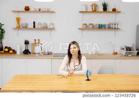 Caucasian student girl smiles, looking to camera and studies geography on a globe while sitting at home in quarantine. Education abroad. Distance learning 123438726