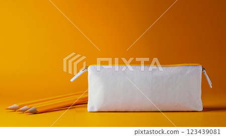 A white pencil case with two yellow pencils on a yellow background A white pencil case with two yellow pencils on a yellow background 123439081
