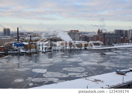 A stunning winter river view featuring an intriguing industrial landscape and thick ice A stunning winter river view featuring an intriguing industrial landscape and thick ice 123439174