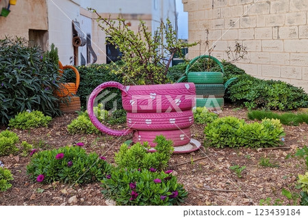 Recycled tires serve as eye-catching garden planters, promoting sustainable landscaping. Upcycling turns waste into art, making outdoor spaces vibrant and environmentally friendly Recycled tires serve as eye-catching garden planters, promoting sustainable landscaping. Upcycling turns waste into art, making outdoor spaces vibrant and environmentally friendly 123439184