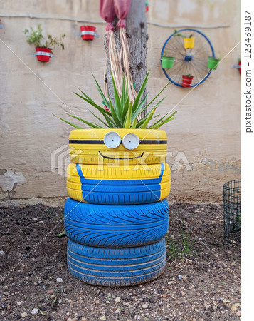 Upcycled tires become artistic garden planters, showcasing handmade creativity. Playful faces and bold colors enhance outdoor aesthetics, proving sustainability can be stylish Upcycled tires become artistic garden planters, showcasing handmade creativity. Playful faces and bold colors enhance outdoor aesthetics, proving sustainability can be stylish 123439187