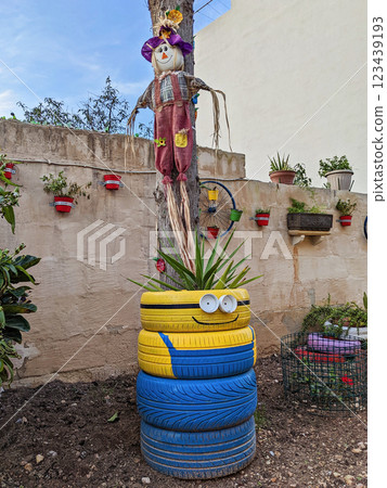 Old tires find new life as eco-friendly planters, creatively designed for sustainable gardening. Bright colors and fun shapes add a unique touch to upcycled green spaces 123439193