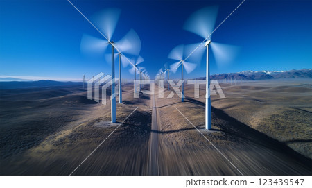 A low-flying drone speeds past wind turbines. 123439547