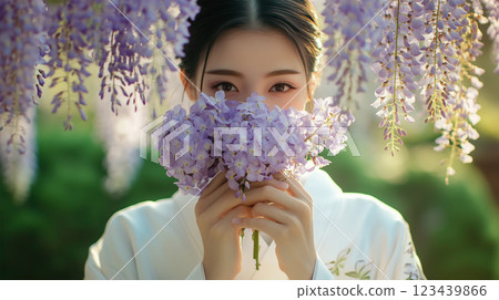 日本女子在紫花園裡用一束花遮住臉 日本女子在紫花園裡用一束花遮住臉 123439866