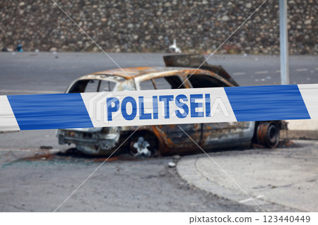 Estonian police tape in front of a burnt car 123440449
