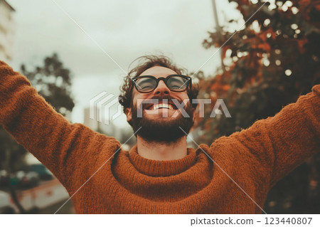 Joyful man in a cozy sweater outdoors 123440807