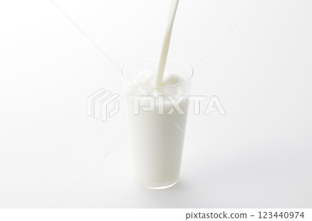 白色背景下，牛奶倒進玻璃杯 123440974