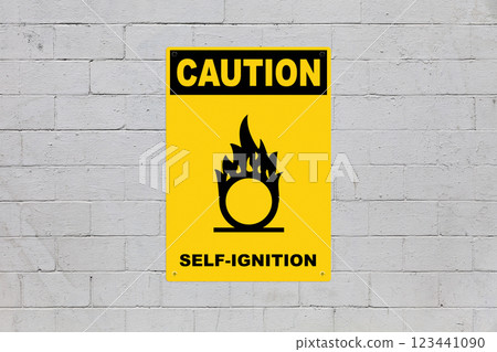 Caution, Self ignition - Sign on a cinder block wall 123441090