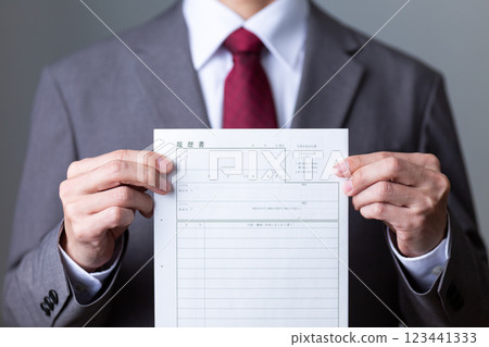 一位身穿灰色西裝、手持履歷的中年男性商人 123441333