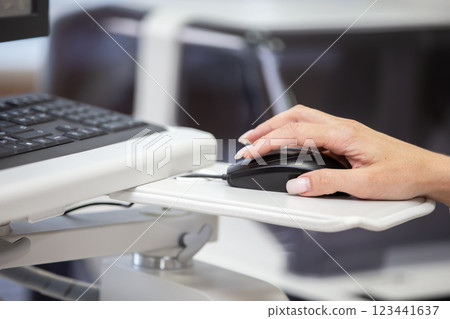 The hand holds a computer mouse against the background of the keyboard. The hand holds a computer mouse against the background of the keyboard. 123441637