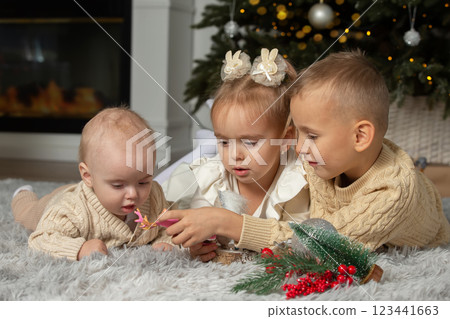 Small children brothers and sisters at the Christmas tree. Children on Christmas Eve. Small children brothers and sisters at the Christmas tree. Children on Christmas Eve. 123441663