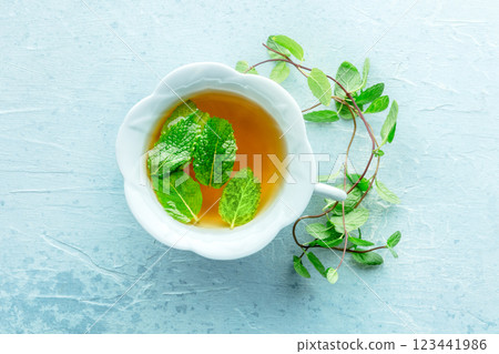 Mint tea. A cup of peppermint tea with fresh mint leaves, overhead Mint tea. A cup of peppermint tea with fresh mint leaves, overhead 123441986