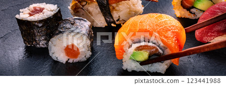 Sushi rolls on a black background panorama. Uramaki with salmon Sushi rolls on a black background panorama. Uramaki with salmon 123441988