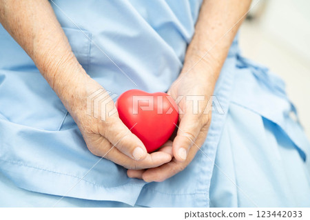 Asian elder senior woman patient holding red heart in hospital. 123442033